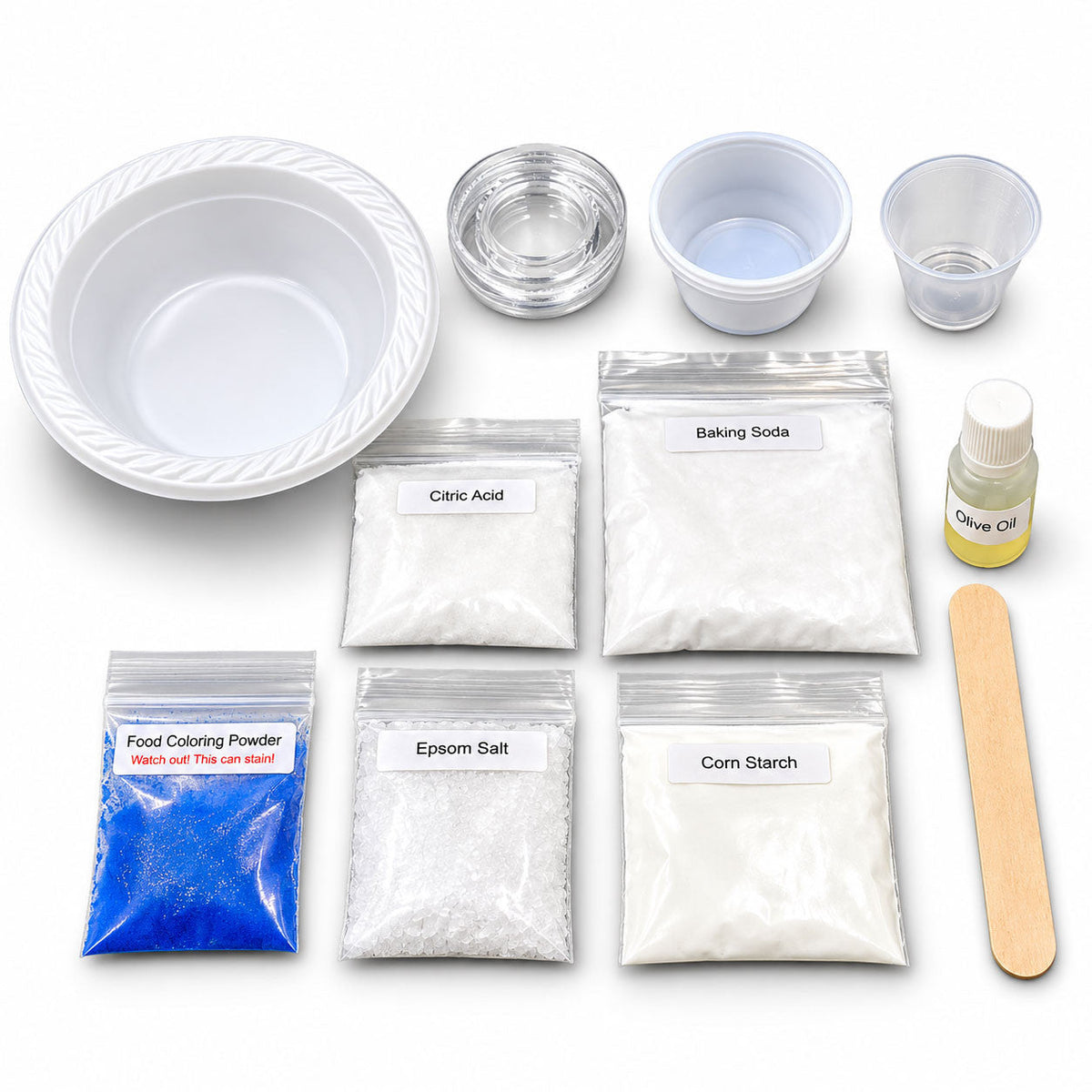 The kit laid out: a bowl, cups with lids, a measuring cup, labeled bags of baking soda, citric acid, corn starch, Epsom salt and food coloring powder, a bottle of olive oil and a craft stick.