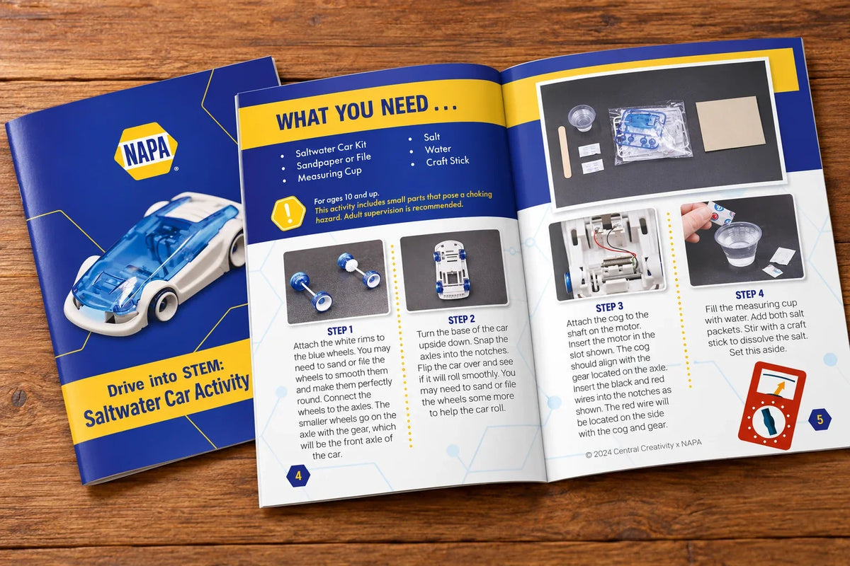 The Saltwater Car Activity guide open on a wooden table, its cover showing the finished car and the spread showing What You Need and the first four build steps.