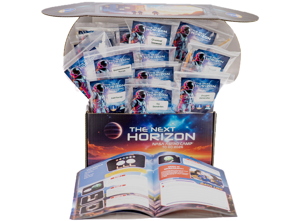 The Next Horizon Astro Camp kit, a clear tub packed with individually sealed student activity packets, with the printed teacher guide lying open in front of it.