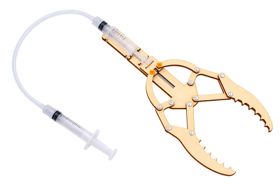 An assembled Hydraulic Gripper: two syringes joined by a clear hose, driving a wooden toothed claw