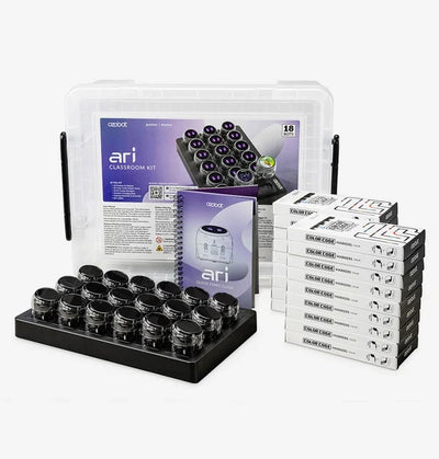 The Ari Classroom Kit for eighteen: a clear lidded storage tub, the lesson folder and quick start guide, eighteen Ari robots seated in a black charging tray, and a stack of Color Code marker boxes.