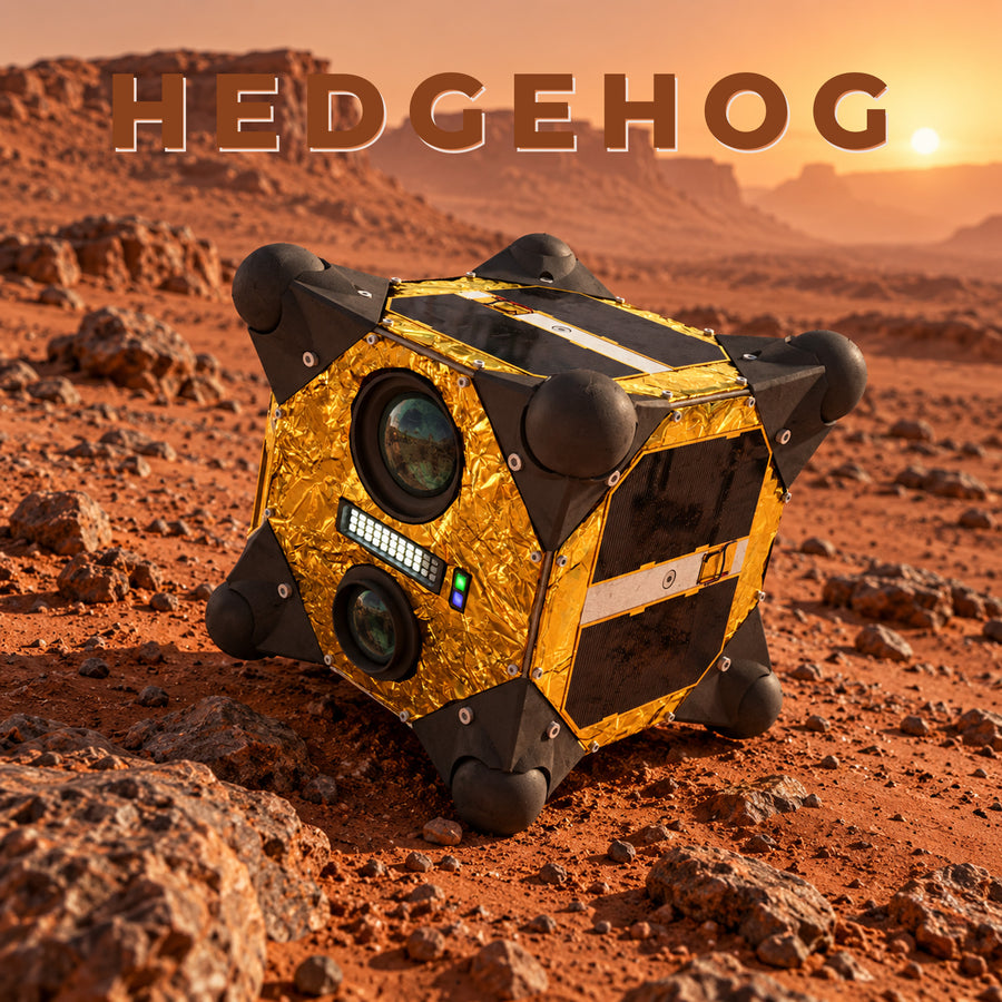 NASA's Hedgehog robot: a cube with blunt spikes at each corner and gold foil panels, sitting on rocky reddish ground at sunset.