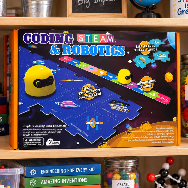 The Coding STEAM and Robotics box, showing the yellow robot on an interlocking puzzle-card map with a row of colored command tiles running across it