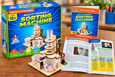 The Sorting Machine Kit box, the built machine and the open instruction manual together on a desk