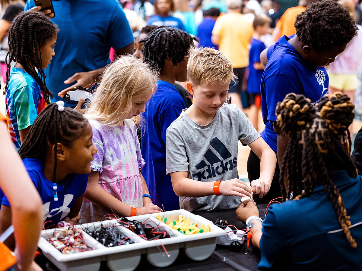 A STEM event station with families queuing